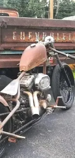 Vintage motorcycle and truck on pavement with rustic charm.