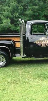 Vintage black truck in green forest wallpaper.