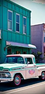 Vintage teal truck parked on a colorful city street with retro buildings.