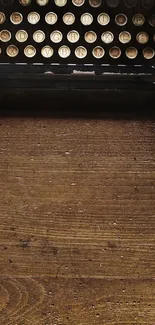 Vintage typewriter on rustic wooden desk wallpaper.
