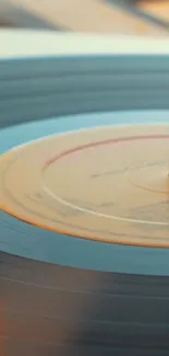 Close-up of a vintage vinyl record with warm orange tones.