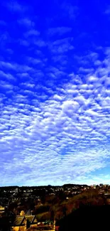 Blue sky and fluffy clouds over a scenic landscape wallpaper.