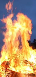 Vivid bonfire blazing against a dark night sky, reflecting in a tranquil lake.