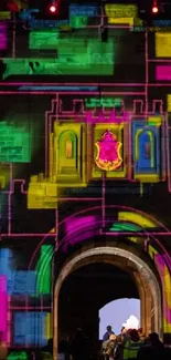 Colorful castle wall illuminated with geometric light patterns at night.