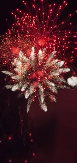 Vivid red and white fireworks exploding in a dark night sky wallpaper.