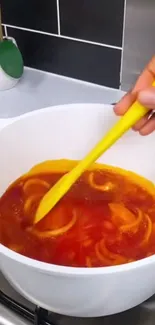 Colorful pot of food with orange hues in kitchen setting.