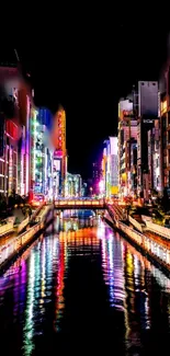 Colorful city nightscape with neon reflections on water.