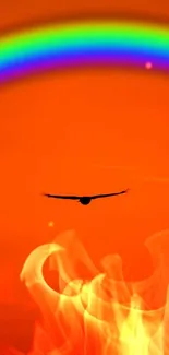 Vibrant orange sky wallpaper with rainbow and flying bird.