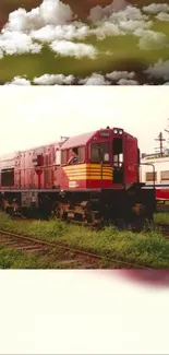 Classic red train on green tracks with cloudy sky.