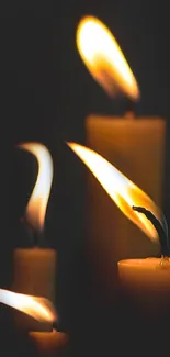 Warm candle flames in the dark creating a cozy atmosphere.