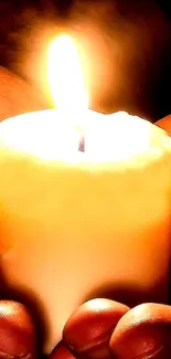 Hand-held glowing candle emitting serene and warm light.