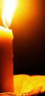 A glowing candle with a warm, orange hue illuminating the darkness.