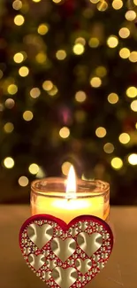 Candle with heart design in front of a festive bokeh background.