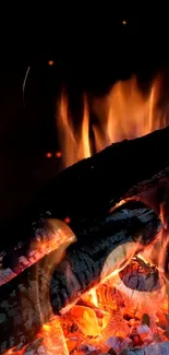 Mobile wallpaper of a crackling fireplace with glowing orange flames.