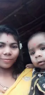 Woman and baby in traditional attire, smiling warmly.