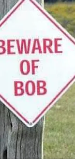 Beware of Bob sign on a post with natural background.