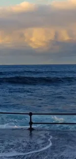 Serene ocean view at sunset with golden clouds and waves.