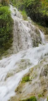 Waterfall cascading over rocks with lush greenery.