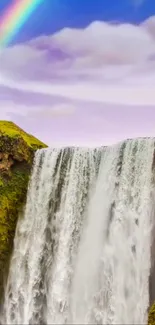 Majestic waterfall with a rainbow in a serene landscape under a blue sky.