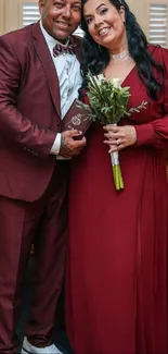 Elegant couple in burgundy attire celebrating their wedding.