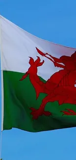 Welsh flag waving against a blue sky backdrop.