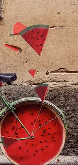 Bicycle with watermelon wheels against a rustic wall art backdrop.