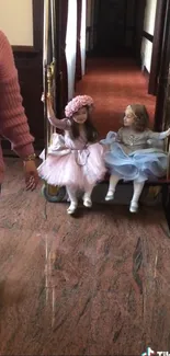 Two young girls in dresses enjoying a playful moment indoors.