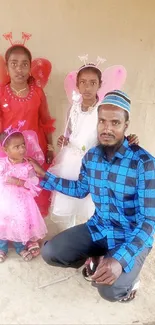 Family photo with vibrant blue and pink outfits, featuring whimsical fairy costumes.