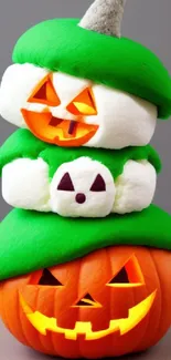 Whimsical stack of green-capped pumpkins with smiling faces.