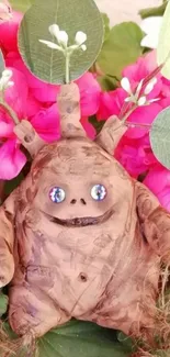 Handmade creature with pink flowers background.