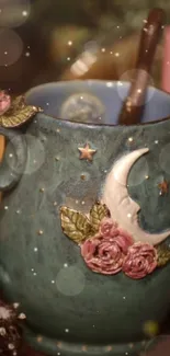 Green mug with moon, roses, and stars design.