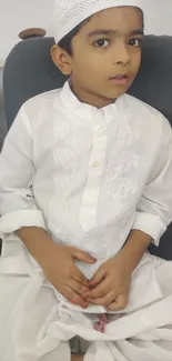 Child in traditional white attire seated