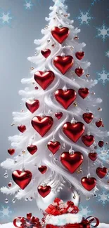 White Christmas tree with red heart ornaments, perfect for festive decor.