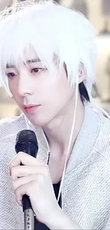 White-haired singer with serene expression holding microphone.