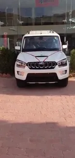 Front view of a white SUV parked in a showroom driveway.