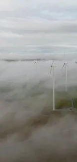 Aerial view of wind turbines emerging through misty clouds.