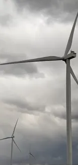 Wind turbines standing tall against a cloudy sky.