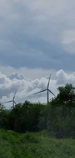 Wind turbines against a cloudy sky, lush green landscape.