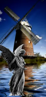 Angel statue with windmill reflecting on water.