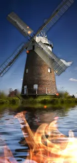 Windmill reflecting in water with fiery flames.