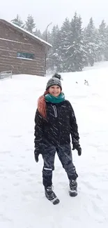 Person enjoying snowy winter landscape with trees and building.