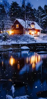 Snowy cabin by a lake with warm light reflections at night.