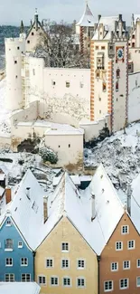 Snowy castle with colorful homes in winter scene.