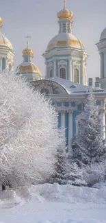 Snowy cathedral with golden domes in a serene winter landscape.