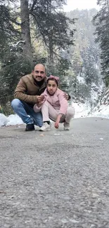 Father and daughter on snowy forest road in winter.