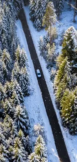 Aerial view of a scenic snowy forest road with frosty trees and a moving car.