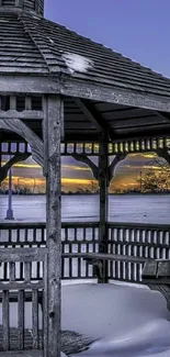 Snow-covered gazebo with purple sunset sky.