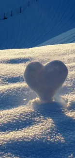 Heart-shaped snow sculpture in golden sunlight on a snowy landscape.