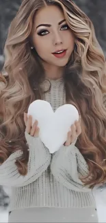 Woman holding heart-shaped snow in winter scene.