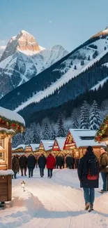 Snowy village market with mountains under a clear blue sky.